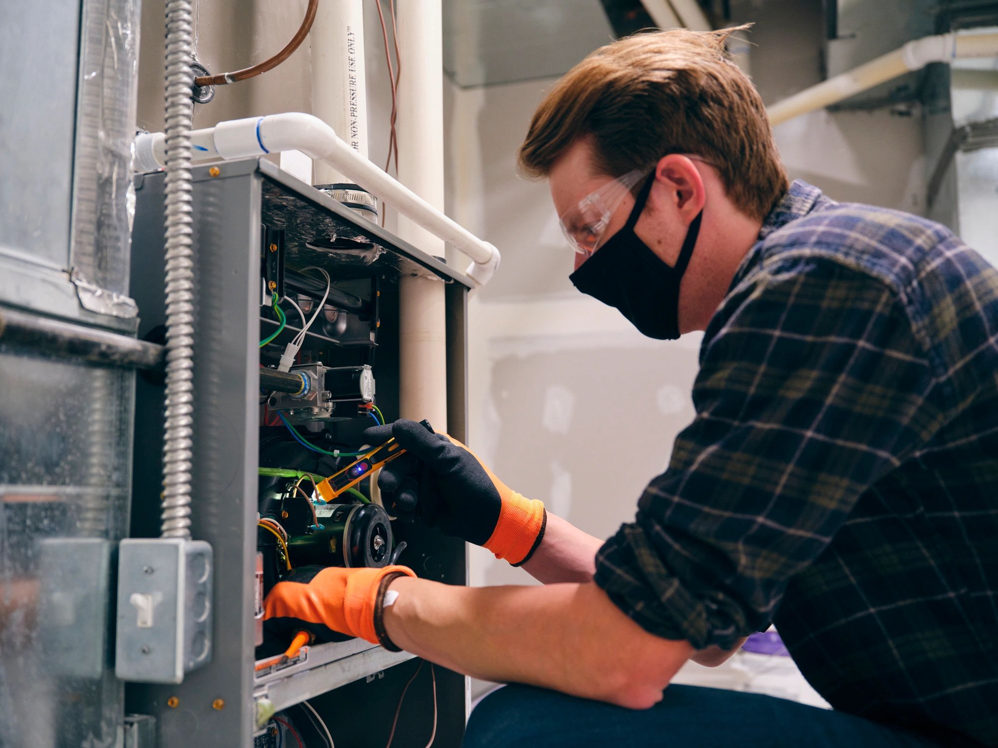 HVAC professional inspecting equipment in a home