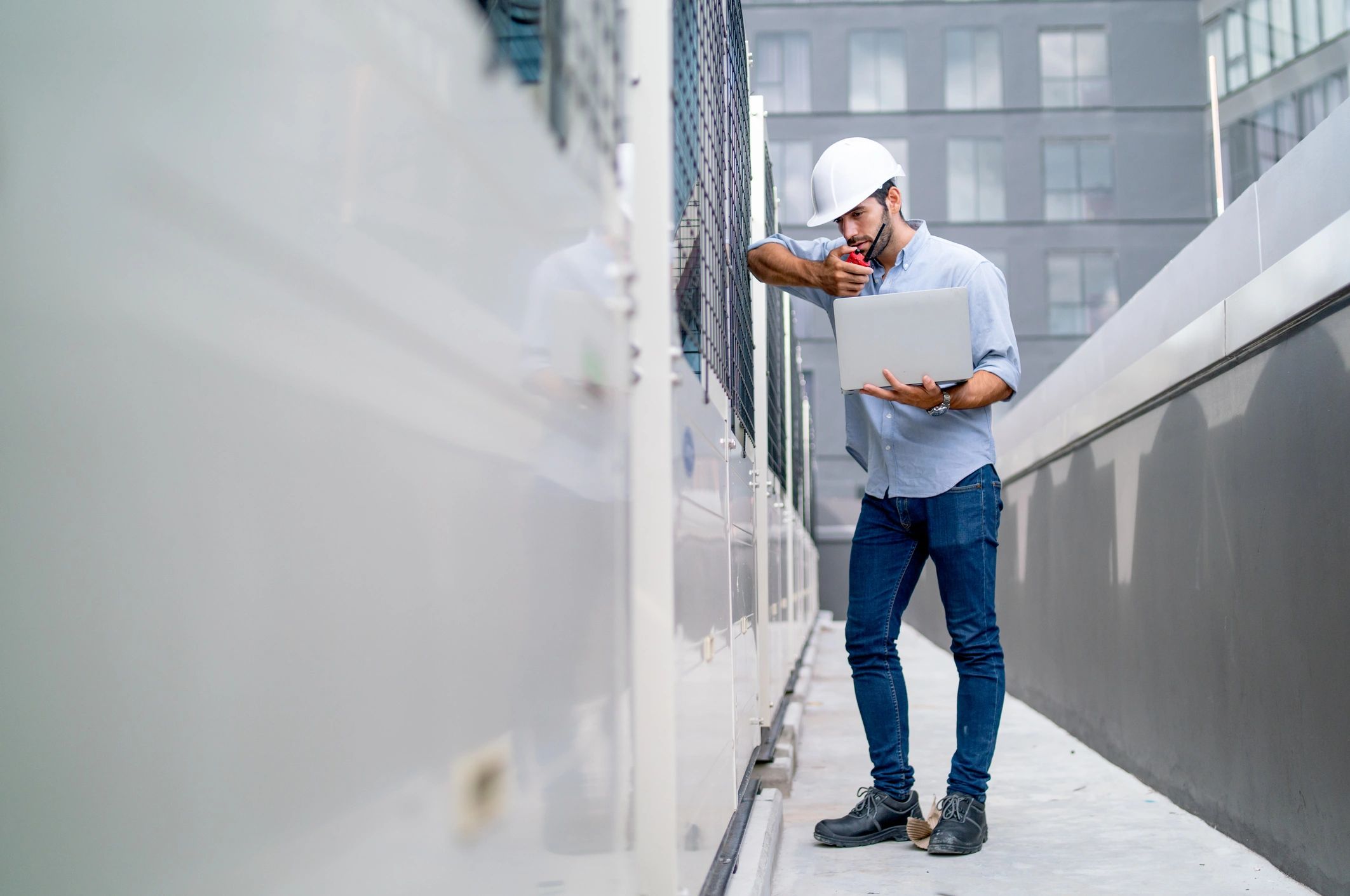 Technician using a laptop on a job site, representing secure handling of customer information.